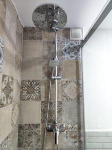 y baño con ducha y azulejos en la pared. en APARTEMENTO EN LA RIBERA, en Córdoba
