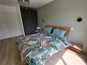 ein Schlafzimmer mit einem großen Bett mit einer bunten Bettdecke in der Unterkunft Villa Lou Sanaé - Bord de mer - Spa, paddle, Kayak - Classé 4 étoiles in Santec