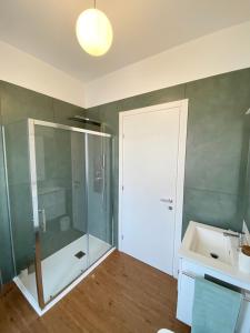 y baño con ducha acristalada y lavamanos. en Casa Dell'Edera - Holiday Apartment in Domodossola en Domodossola