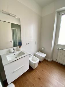 biała łazienka z umywalką i toaletą w obiekcie Casa Dell'Edera - Holiday Apartment in Domodossola w mieście Domodossola