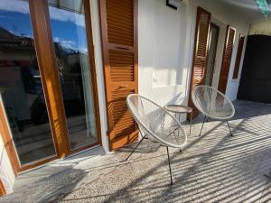 dwa krzesła siedzące na ganku domu w obiekcie Casa Dell'Edera - Holiday Apartment in Domodossola w mieście Domodossola
