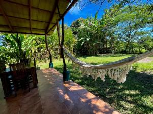 una hamaca en el porche de una casa en Secret Garden Santa Teresa - Cabuya, en Cabuya