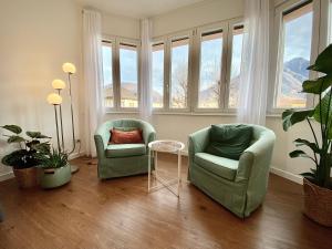 2 stoelen en een tafel in een kamer met ramen bij Casa Dell'Edera - Holiday Apartment in Domodossola in Domodossola