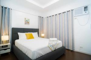 3bd Lux City Oasis Las Pinas في مانيلا: غرفة نوم بسرير ابيض كبير ونافذة