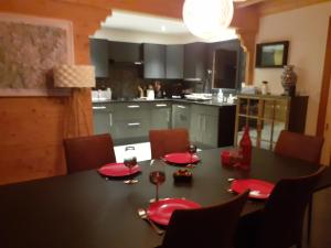 a kitchen with a table with red plates and wine glasses at Charmant chalet 8p calme et vue sur montagnes in Verchères +6 photos