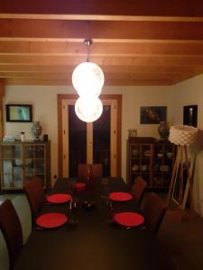 a dining room with a table and a chandelier at Charmant chalet 8p calme et vue sur montagnes in Verchères