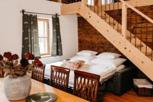 a room with a bed and a table and stairs at Speckleitengut in Kuchl