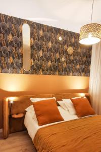 ein Schlafzimmer mit einem großen Bett mit einer Wand in der Unterkunft Les Appartements de la Nef d'Or in Saint-Quentin
