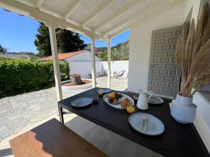 - une table avec des assiettes de nourriture sur la terrasse dans l'établissement Villa Filira, à Achladies
