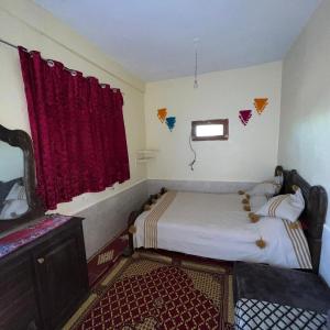 a small bedroom with a bed and a window at auberge touristique zriouila in Guelmim