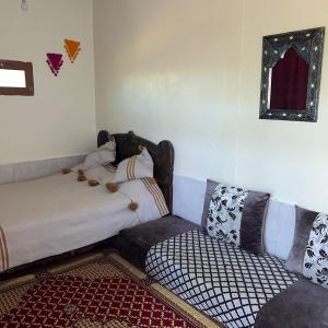 Habitación con sofá, cama y silla en auberge touristique zriouila en Guelmim