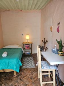 Schlafzimmer mit einem Bett, einem Tisch und einem Schreibtisch in der Unterkunft Hostal Casa Amarilla Tecámac in Santa Cruz Tecamac
