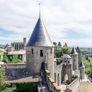 un vieux château avec une tour en haut dans l'établissement La maison de Camille climatisation parking privé WIFI, à Carcassonne