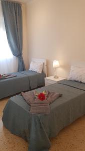 巴里Residenze Benedetto Croce的一间设有两张带毛巾和灯的床的房间