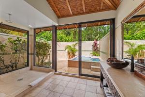 baño interior con bañera y ventanas grandes en Sleeping Giant Rainforest Lodge en Belmopan