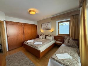 a hotel room with two beds and a window at MB Apartment in Ramsau im Zillertal