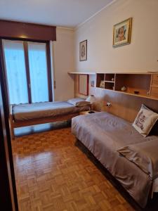 a hotel room with two beds and a window at La casa di Giò in Tirano