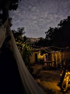 a man in a hammock in a yard with lights at Hostal Casa Amarilla Tecámac in Santa Cruz Tecamac