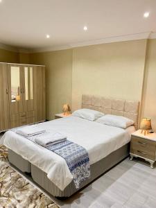 a large bed in a bedroom with two lamps at Clock Towers Life in Balıkesir