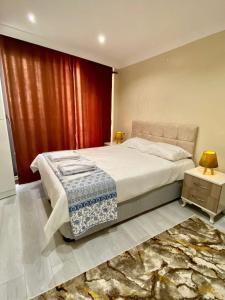 1 dormitorio con 1 cama grande y cortina roja en Clock Towers Life en Balıkesir