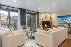 Una sala de estar con muebles blancos y chimenea. en Enzian at Vail 117, en Vail