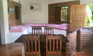 Habitación con almohadas rosas, mesa y sillas. en Pousada Lawrence, en Itacaré