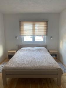 Un dormitorio con una cama y una ventana con persianas. en Studio Apartmani V&V, en Žabljak 16 fotos más
