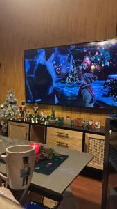 a living room with a table and a large tv at Chalet Látky in Látky