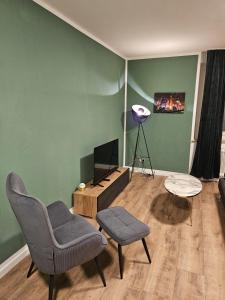 ein Wohnzimmer mit einem Sofa und einem TV in der Unterkunft Sweet Home - 5 - in Duisburg