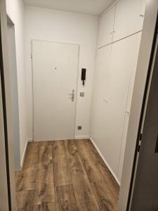 ein leeres Zimmer mit einer weißen Tür und Holzböden in der Unterkunft Sweet Home - 5 - in Duisburg
