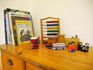 ein Regal mit Spielzeug auf einer Kommode mit Büchern in der Unterkunft Ferienwohnung Unter den Linden in Rietberg