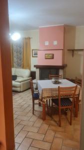 a living room with a table and a fireplace at Casa Fiore in Cerreto di Spoleto