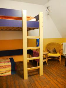 ein Schlafzimmer mit Etagenbetten mit einem Tisch und einem Stuhl in der Unterkunft Ferienwohnung Unter den Linden in Rietberg