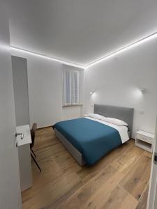 um quarto com uma cama azul e piso em madeira em B&B La Fontana dei Cani em Ascoli Piceno