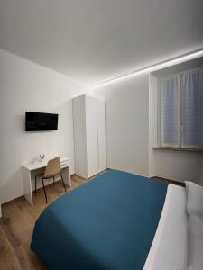 um quarto com uma cama azul e uma secretária em B&B La Fontana dei Cani em Ascoli Piceno
