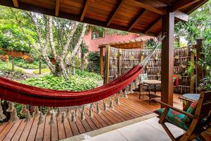 a hammock on a wooden deck with books at Ateliê aconchegante em meio à natureza ATL018 in Florianópolis