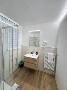 uma casa de banho branca com um lavatório e um chuveiro em B&B La Fontana dei Cani em Ascoli Piceno