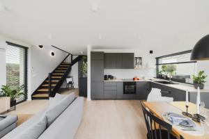 a kitchen and living room with a couch and a table at Kalwa Lake House - dom nad jeziorem z prywatnym pomostem i jacuzzi oraz sprzętem wodnym in Pasym