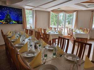 un comedor con una mesa larga con un árbol de Navidad en la pared en Horsky Hotel Mnich, en Bobrovec