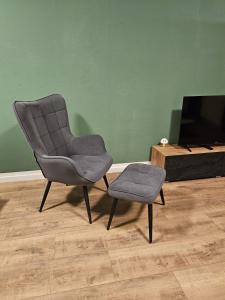 a chair and a stool in a living room at Sweet Home - 5 - in Duisburg