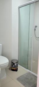 een badkamer met een toilet en een glazen douche bij Suíte em Cobertura, Não é a cobertura toda, somente suíte e piscina in Bombinhas