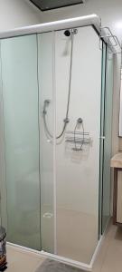 een douche met een glazen deur in de badkamer bij Suíte em Cobertura, Não é a cobertura toda, somente suíte e piscina in Bombinhas