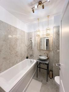 a white bathroom with a tub and a sink at Happy Studio in Bucharest