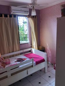 a small bedroom with a bed with a pink sheet at Apartamento 3 quartos temporada São Luís in São Luís