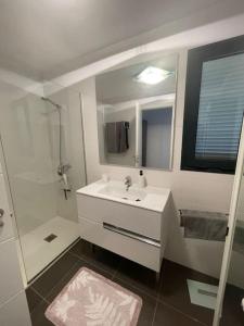 a white bathroom with a sink and a shower at Paraiso in Villaverde
