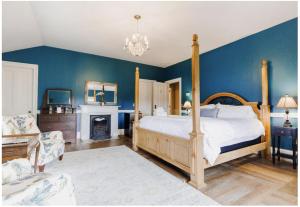 a bedroom with blue walls and a bed and a fireplace at The Hamilton Hoppin House in Middletown