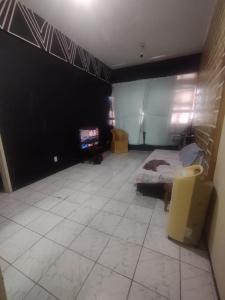 - une chambre avec un lit et une télévision dans l'établissement Casa da Nanda, à Fortaleza