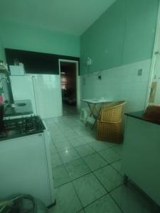 Il comprend une cuisine équipée d'une cuisinière et d'une table. dans l'établissement Casa da Nanda, à Fortaleza