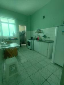 Il comprend une cuisine dotée de carrelage blanc et d'un réfrigérateur. dans l'établissement Casa da Nanda, à Fortaleza