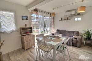 uma sala de estar com uma mesa e cadeiras e um sofá em Villa Tamaris em Gruissan